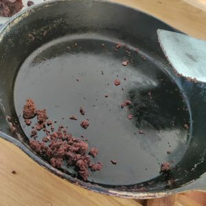 a shiny clean well-seasoned cast iron skillet with just a few crumbs after removing brownies