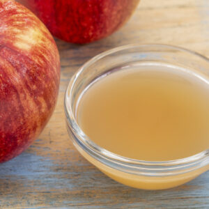 Homemade Fruit Fly Trap with Apple Cider Vinegar 3 unfiltered, raw apple cider vinegar with mother - a small glass bowl with fresh red apples