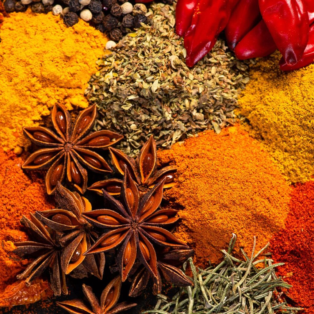 an assortment of spices and herbs on a black background