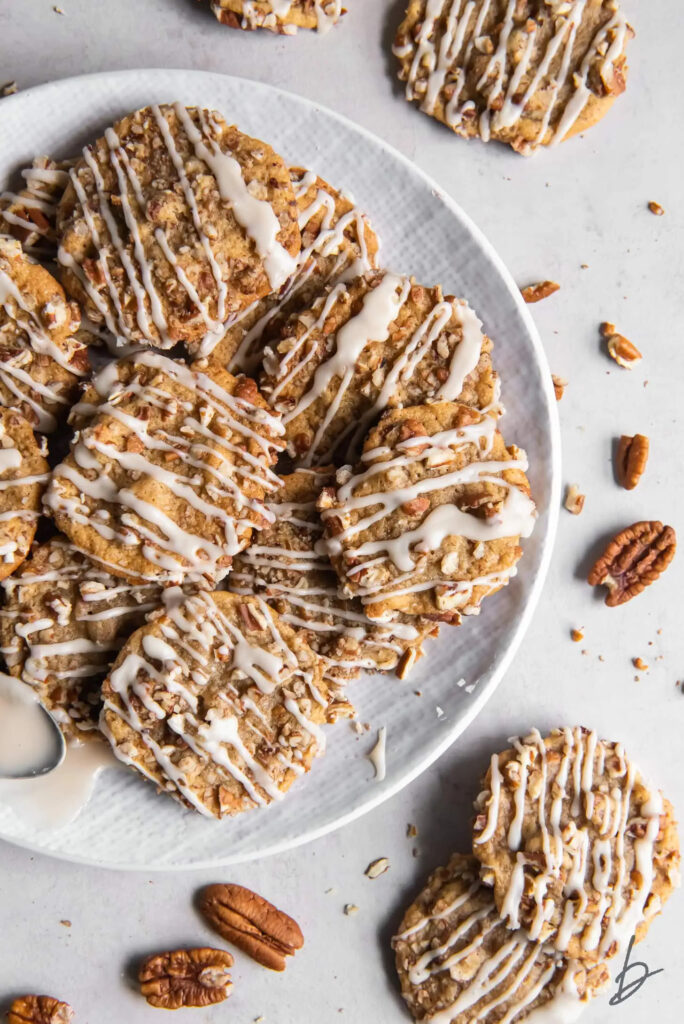 maple brown sugar pecan cookies with chopped pecans and maple drizzle on a plate