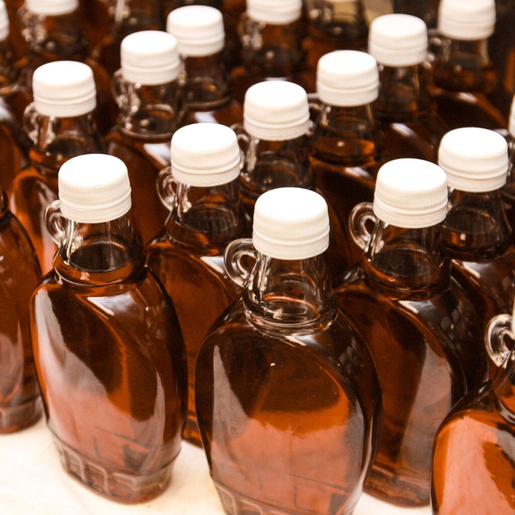 bottles of maple syrup are lined up on a table