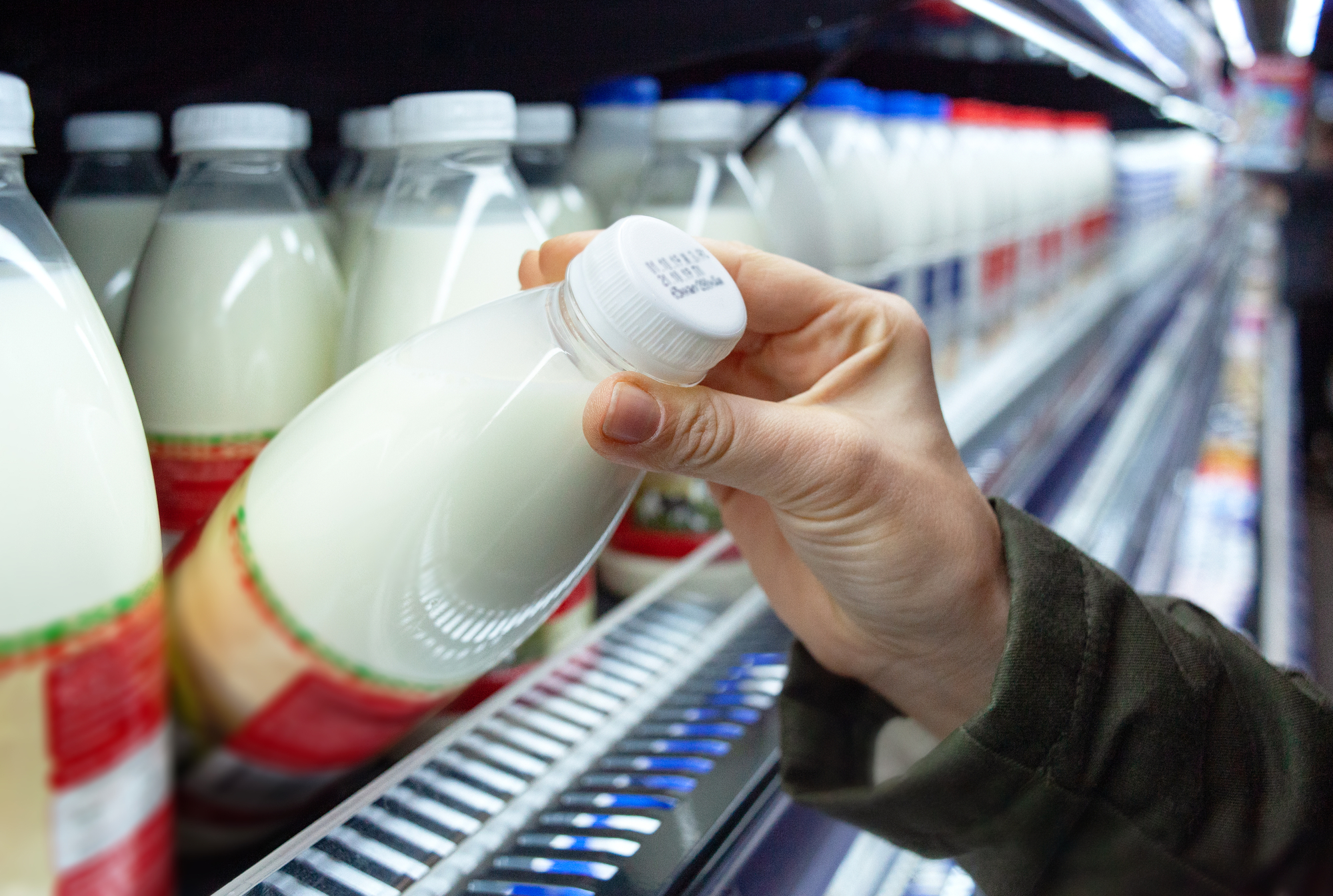 Here's the Secret to Making Your Groceries Last Longer 7 checking expiration date on milk in supermarket