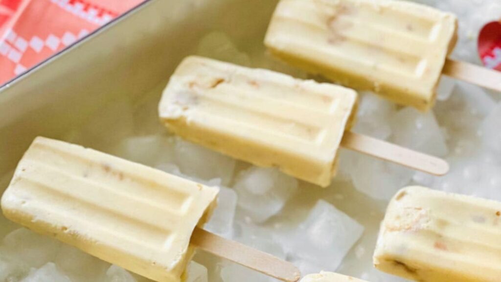 21 Delightful Homemade Popsicle Recipes 16 Six banana popsicles arranged on a bed of ice.