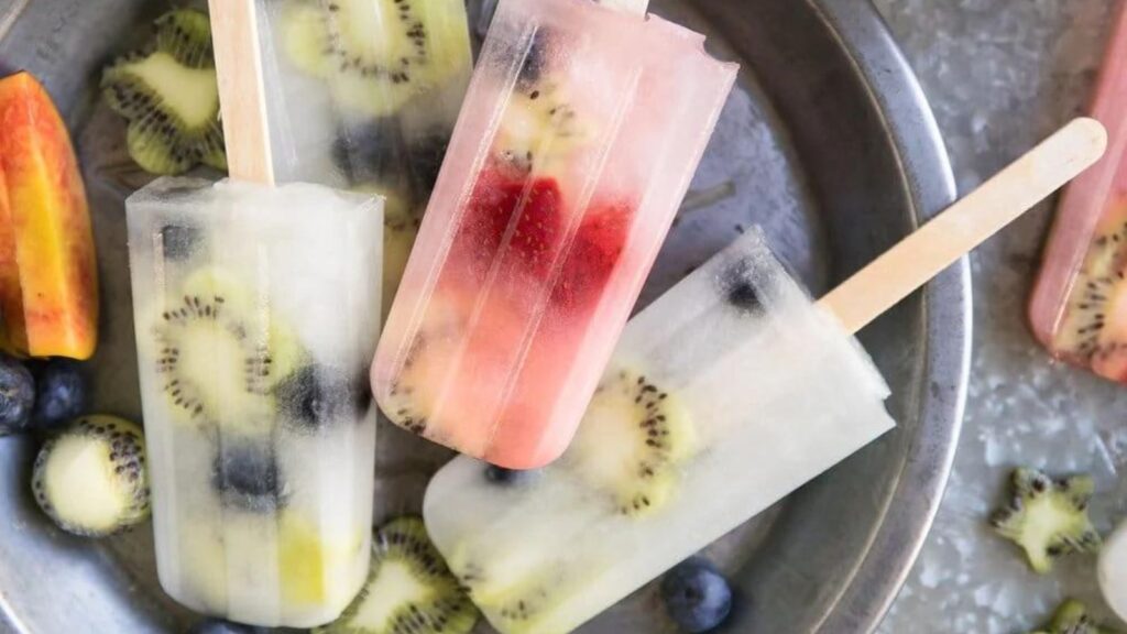 21 Delightful Homemade Popsicle Recipes 10 Homemade lemonade and fruit popsicles on a metal serving tray.