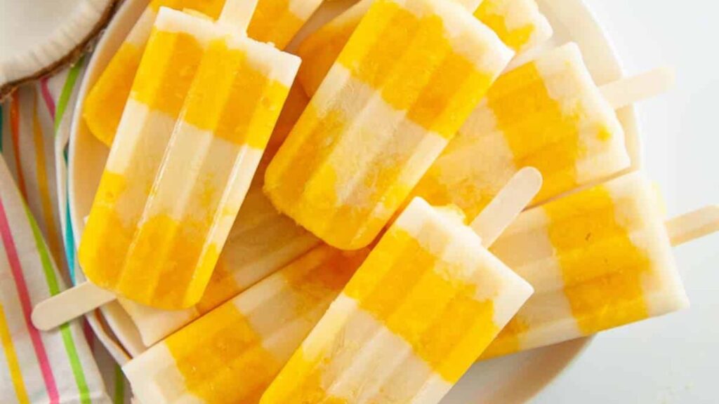 21 Delightful Homemade Popsicle Recipes 5 Mango popsicles on a plate.