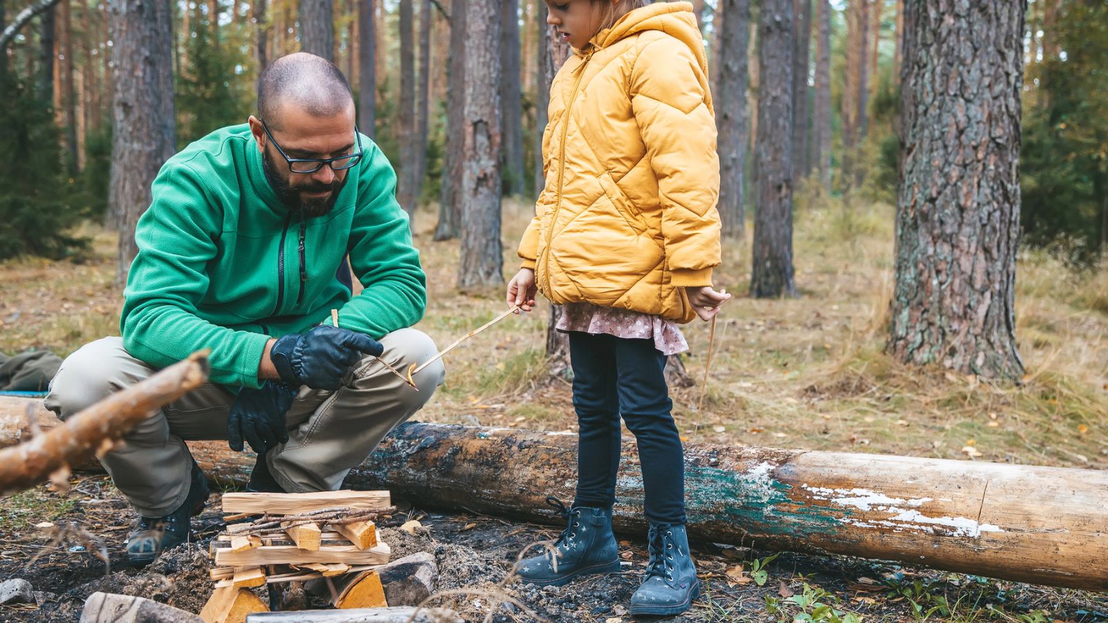 dad showing kid how to start a fire