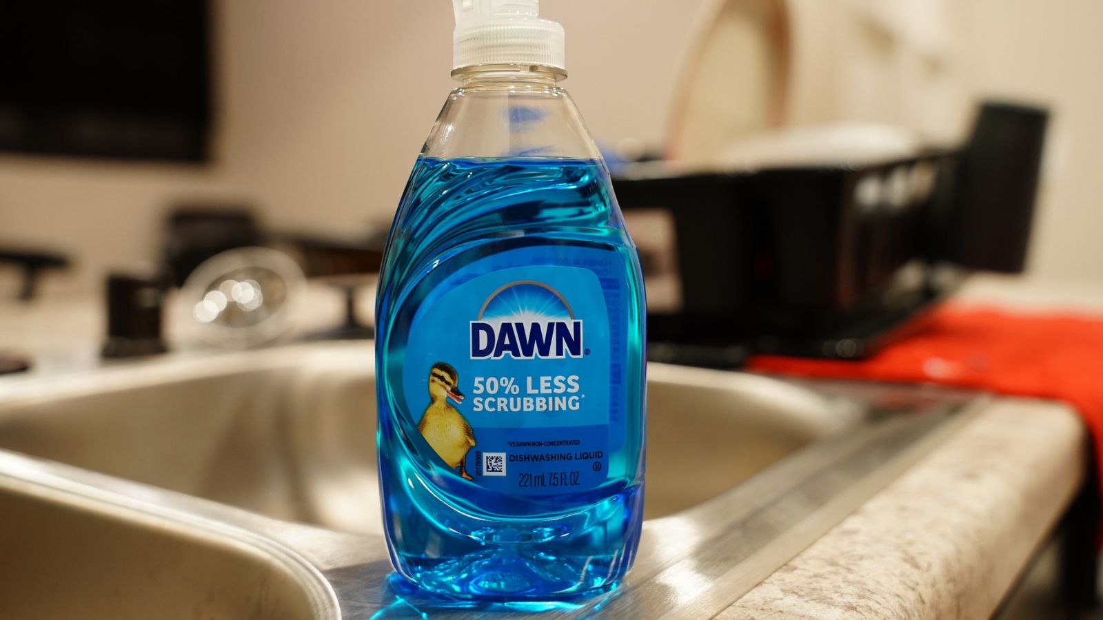 Blue bottle of Dawn dish detergent soap sits on a sink.