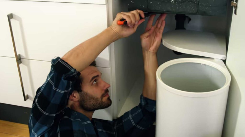 15 Simple Improvements That Add Serious Value to Your Home 1 Man Fixing Kitchen Sink Repairing Plumbing Underneath Cabinet