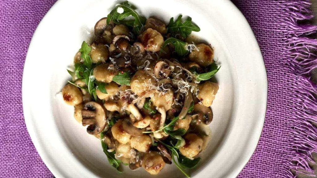 28 Incredibly Tasty Mushroom Recipes With Freshly-Foraged Flavors 18 Easy Parmesan Mushroom Gnocchi on white plate and lavender linen.