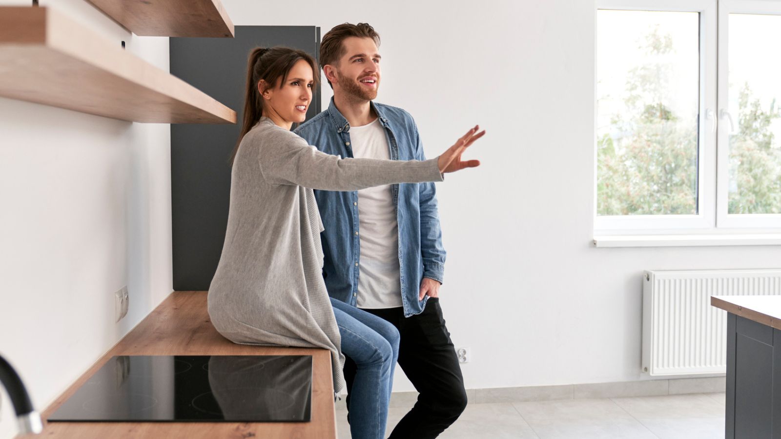 man and woman couple sitting in kitchen in empty house