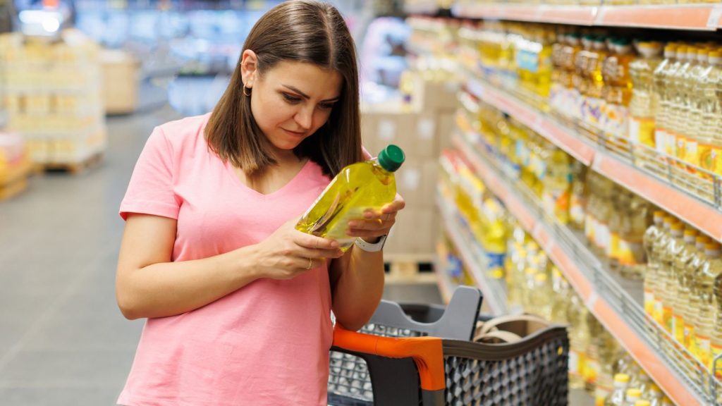 How to Start an Emergency Stockpile When You Can Barely Afford Groceries 6 girl looking at expiration date of food item in supermarket grocery store