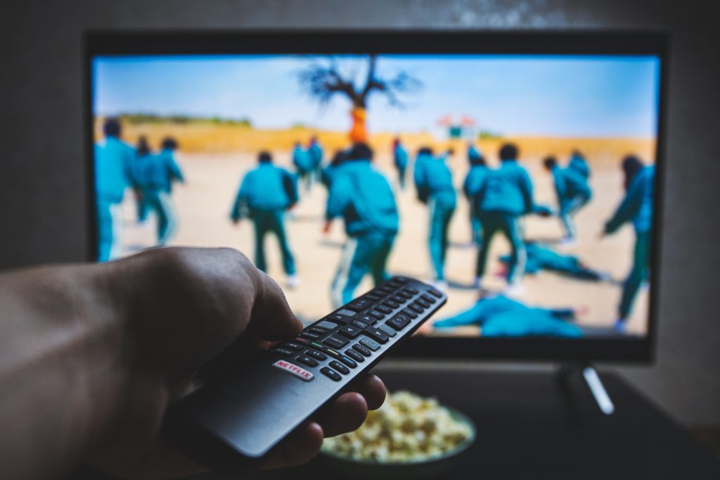 14 Survival Skills You Can Master Without Leaving Your Couch 7 Watching Squid game show on TV. Squid game is a South Korean survival drama television series streaming on Netflix