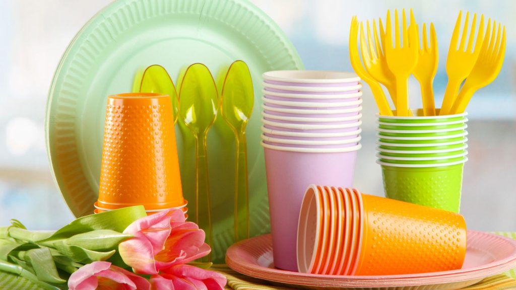 Household Items You Use Every Day That May Be Releasing Microplastics (And What You Can Do About It) 1 Multicolored plastic tableware on table with tulips close up