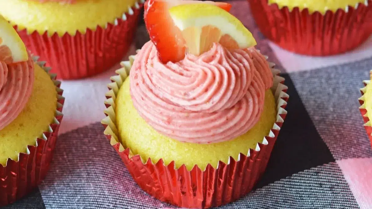 A Sweet Lineup of the Best Cupcake Recipes You’ll Ever Bake 7 A group of cupcakes with pink frosting and lemon slices.