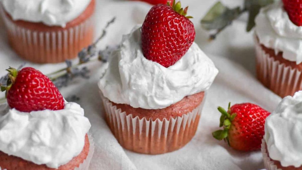 A Sweet Lineup of the Best Cupcake Recipes You’ll Ever Bake 21 Vegan Strawberry and cream cupcakes topped with strawberries on a white cloth