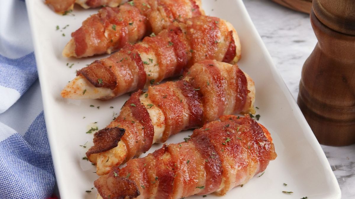The Best Bacon Recipes You’ll Ever Make 3 Bacon wrapped chicken breasts on a white plate.