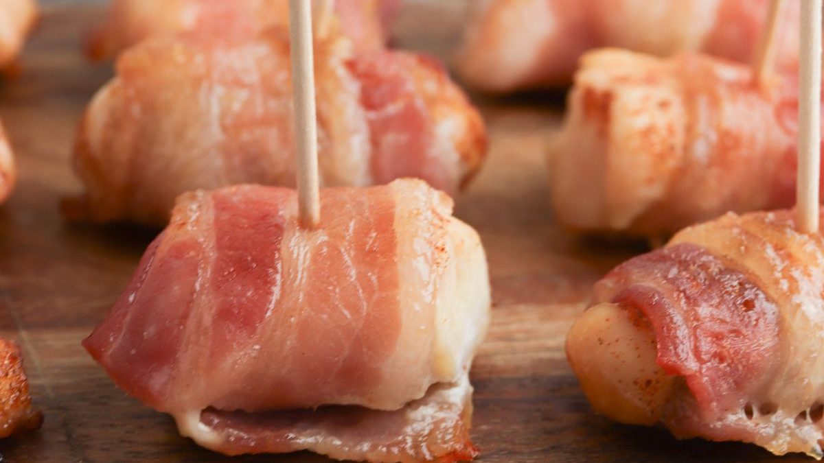 The Best Bacon Recipes You’ll Ever Make 8 Bacon wrapped chicken on a wooden board.