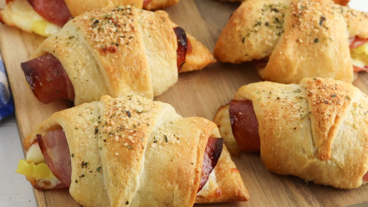 26 Tasty Kids Lunch Ideas To Please Picky Little Eaters 16 Ham and cheese crescent rolls on a wooden cutting board.