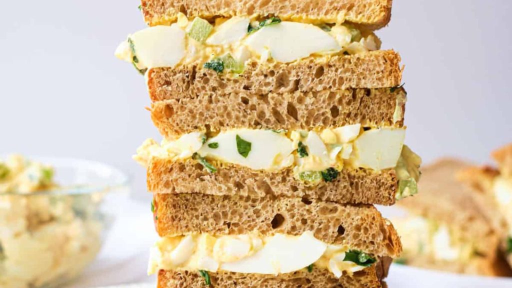 25 Gourmet Sandwiches Perfect for Your Next Lunch Break 17 the finished egg salad sandwich halves stacked vertically