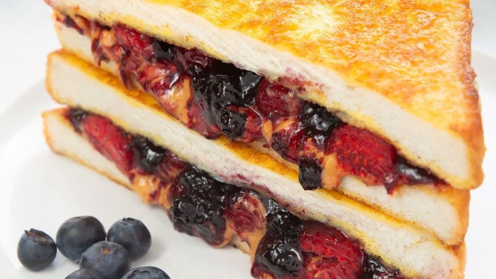 25 Gourmet Sandwiches Perfect for Your Next Lunch Break 15 French Toast peanut butter and jelly sandwich, shown stacked with blueberries.