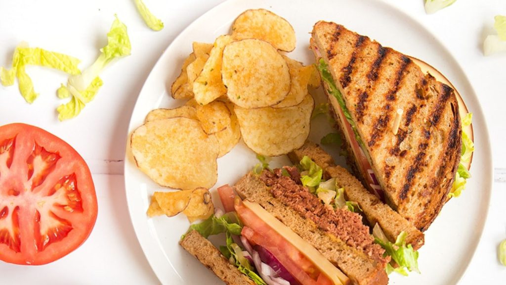 25 Gourmet Sandwiches Perfect for Your Next Lunch Break 1 The finished deli-style corned beef on rye sandwich, shown alongside garnish and crisps.