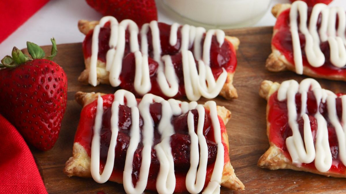 25 Puff Pastry Recipes That Are Flaky, Buttery, and Absolutely Delicious 15 Strawberry shortcakes with icing and strawberries on a cutting board next to a glass of milk.