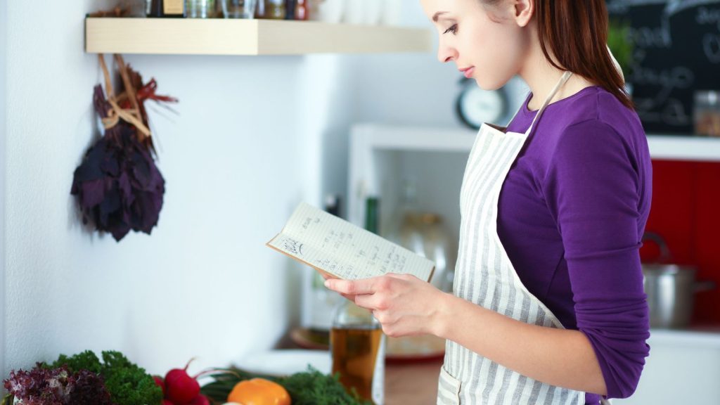 15 Healthy Habits of Highly Effective Preppers 11 a girl with a list in hand in the kitchen pantry