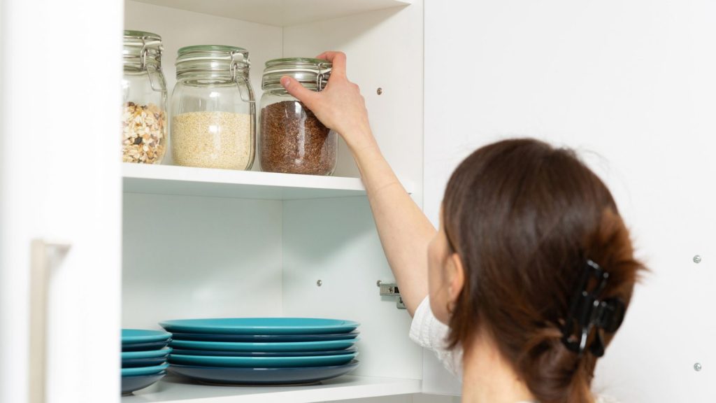 15 Prepper Tasks You Can Do Without Spending a Dime 6 a woman reaching for a jar pantry stock
