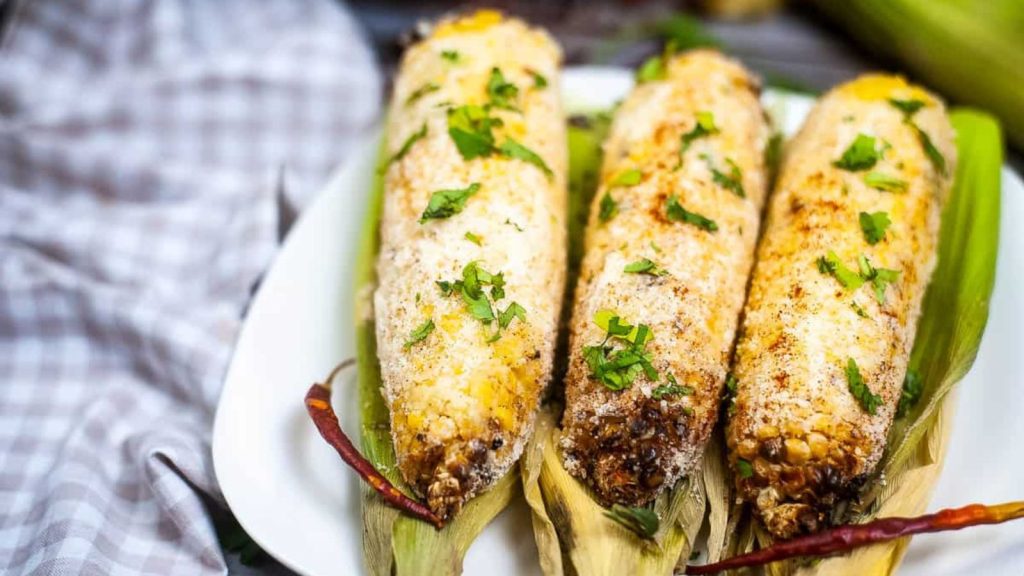 low angle shot of air fryer Mexican corn on the cob.