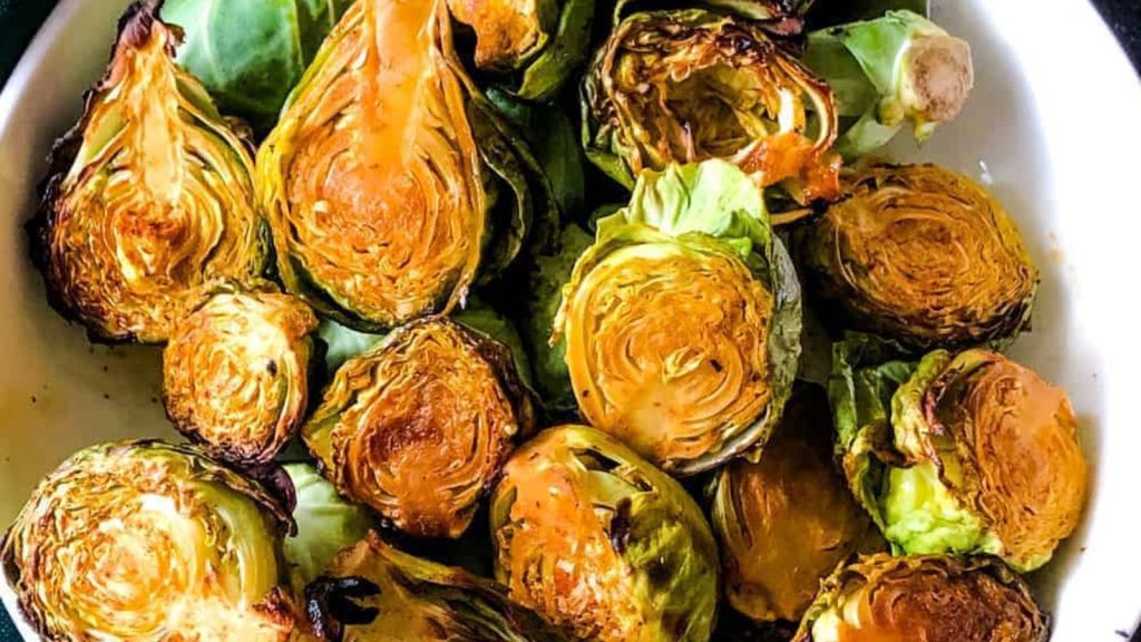 23 Easy, Tasty, and Totally Addictive Air Fryer Vegetables 19 White owl of air-fried Brussels sprouts with fork and green napkin