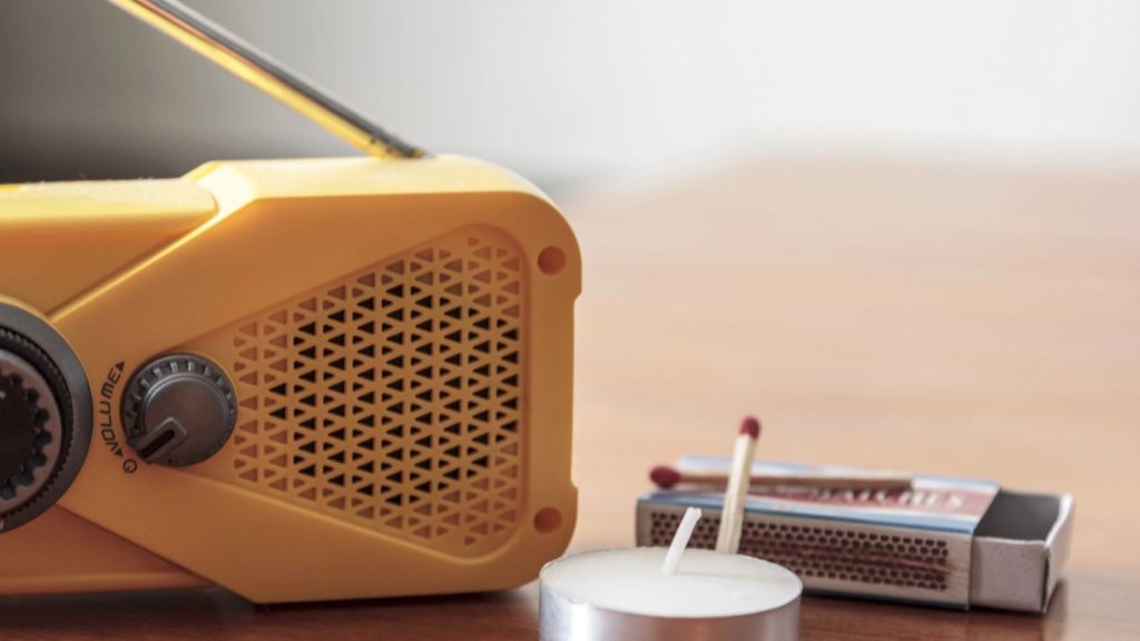 21 Essential Emergency Supplies That Every Home Should Have Stocked 7 radio with a candle and a match beside it
