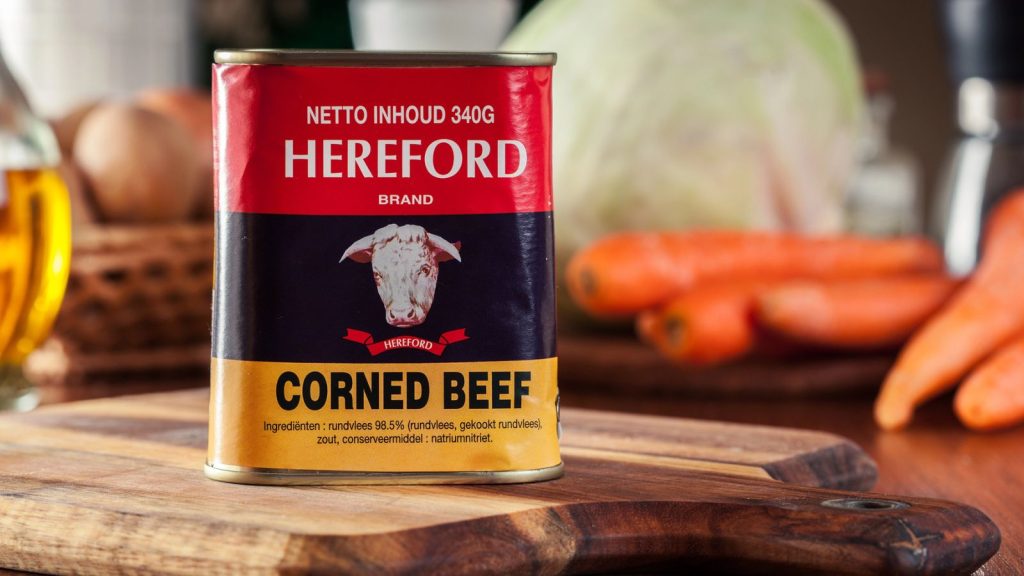 15 Absolute Best Canned Foods to Stockpile in Your Emergency Pantry 4 Can of Hereford Corned Beef on a wooden background