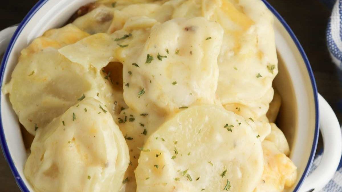 24 Potato Recipes You’ll Never Get Tired Of 7 A bowl of creamy scalloped potatoes garnished with herbs.