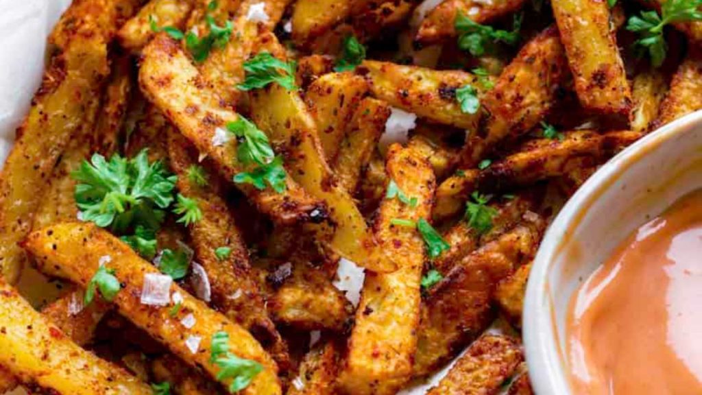 24 Potato Recipes You’ll Never Get Tired Of 9 Five guys Cajun fries served on a baking sheet layered with parchment paper. They're topped with flaky sea salt and chopped parsley.