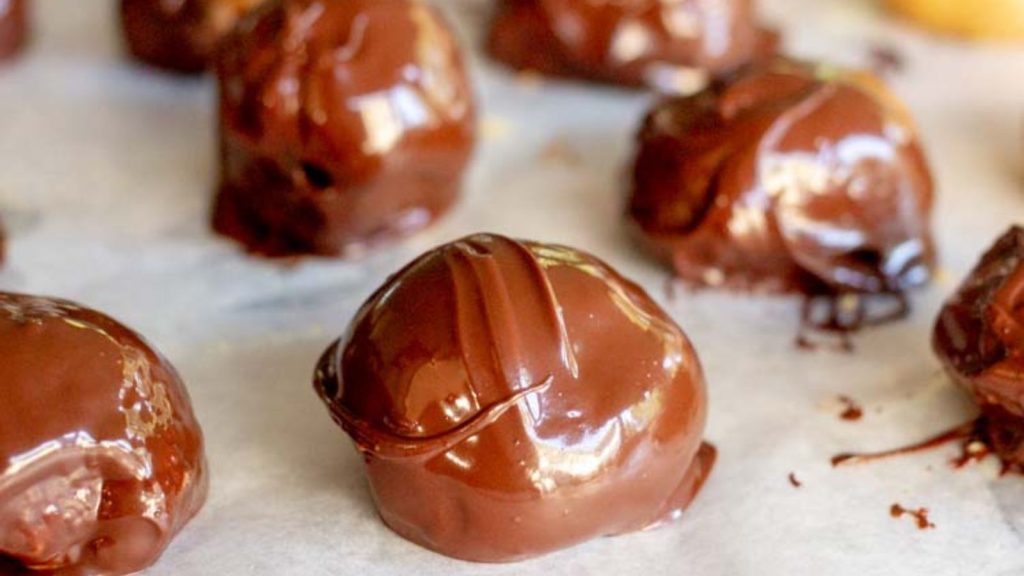 keto peanut butter balls coated in chocolate lined on parchment paper
