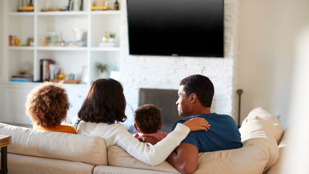 The System I Use to Rotate Food and Avoid Waste in My Stockpile 14 young family sitting on the sofa and watching TV together in their living room